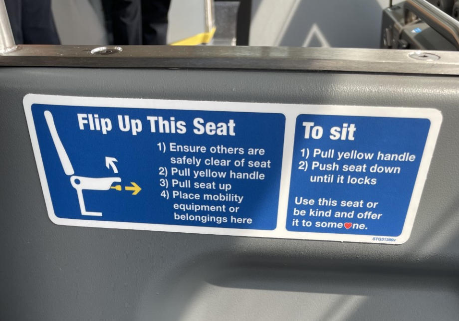 A decal on a seat that reads "Flip Up This Seat" 