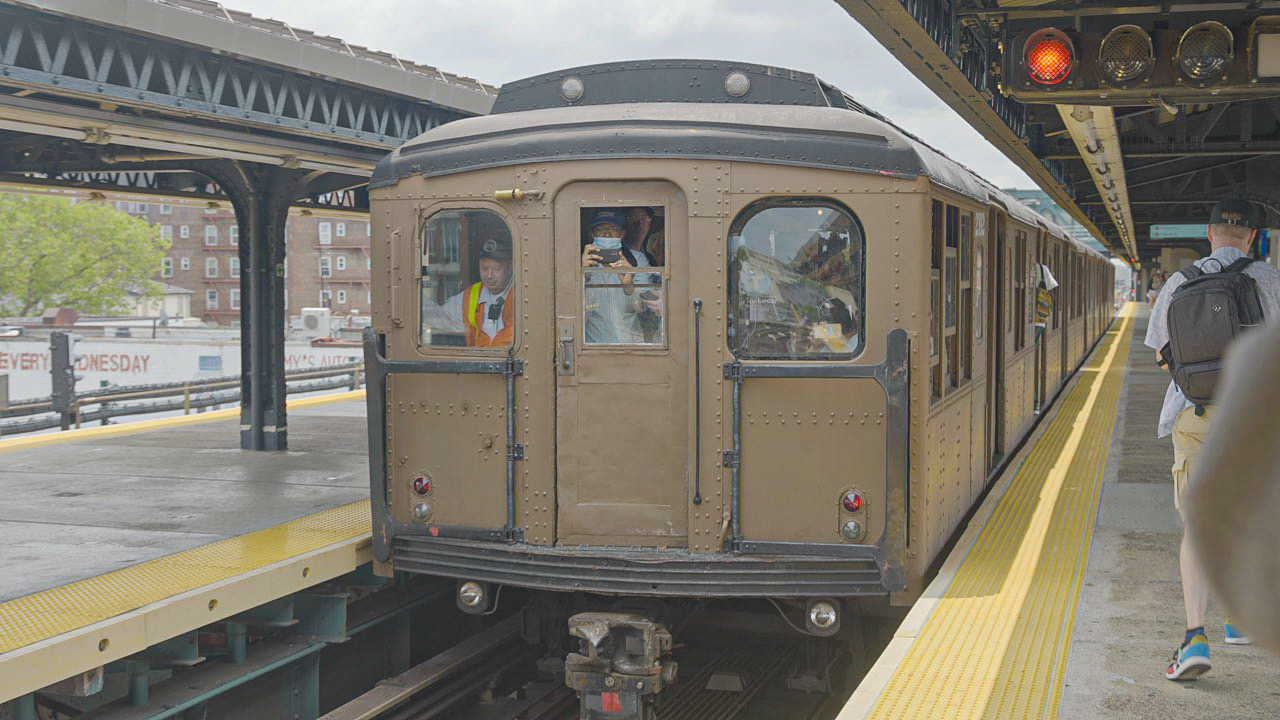 A vintage train car pulled into a subway station.