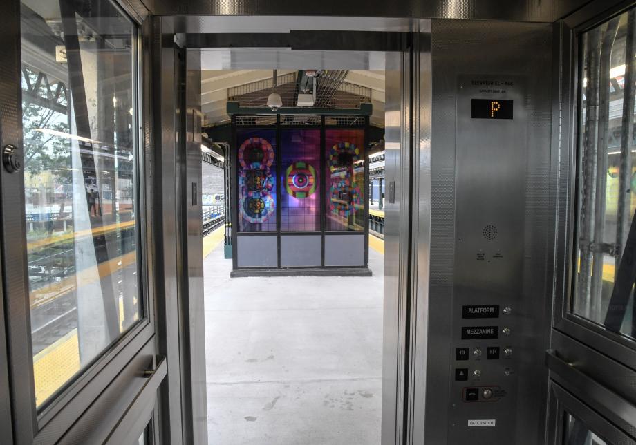From inside the cab of the platform elevator, a photo of the platform and newly installed glass artwork at Astoria Blvd station.
